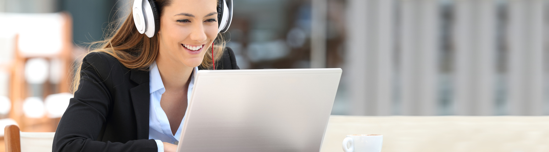 Business-woman-wearing-white-headphones-smiling-while-watching-online-course-from-CSC-Learning-Center